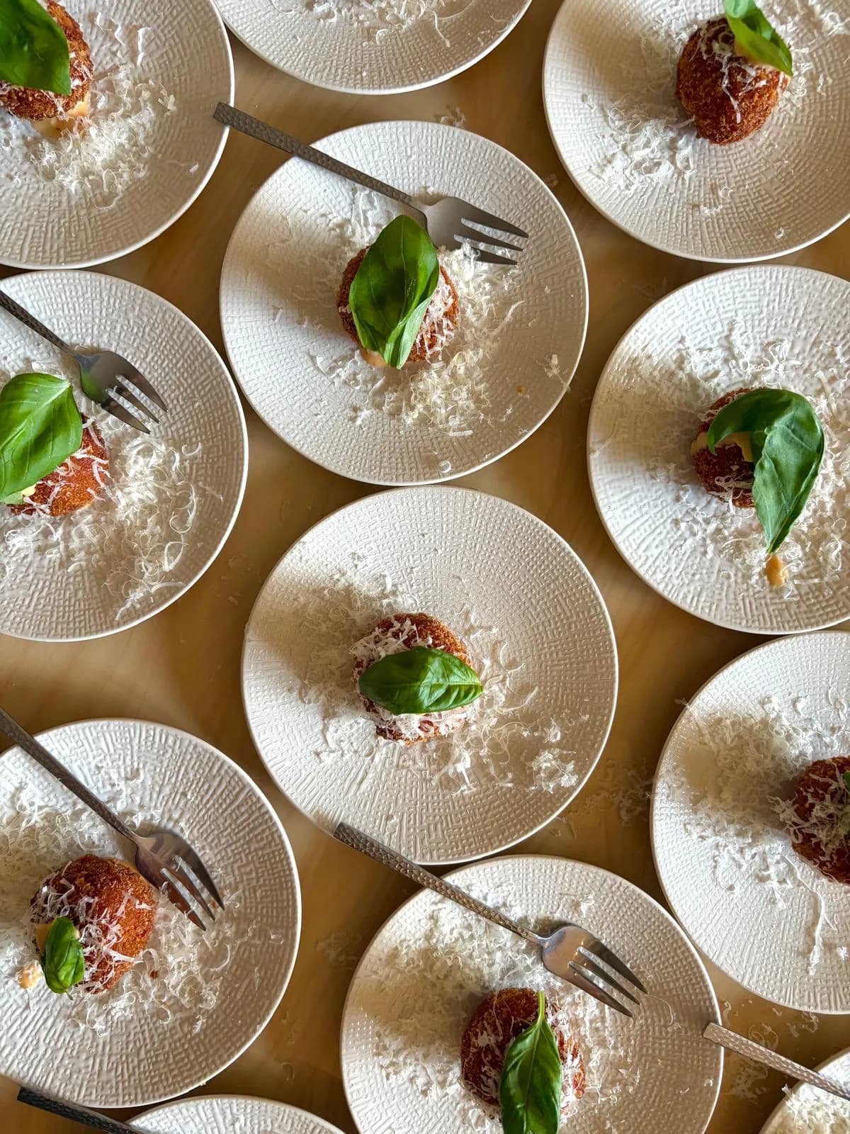 Krokante hapjes met basilicum en geraspte kaas, uitgeserveerd op bordjes